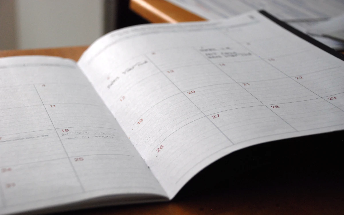 Agenda mensual abierta sobre un escritorio de madera