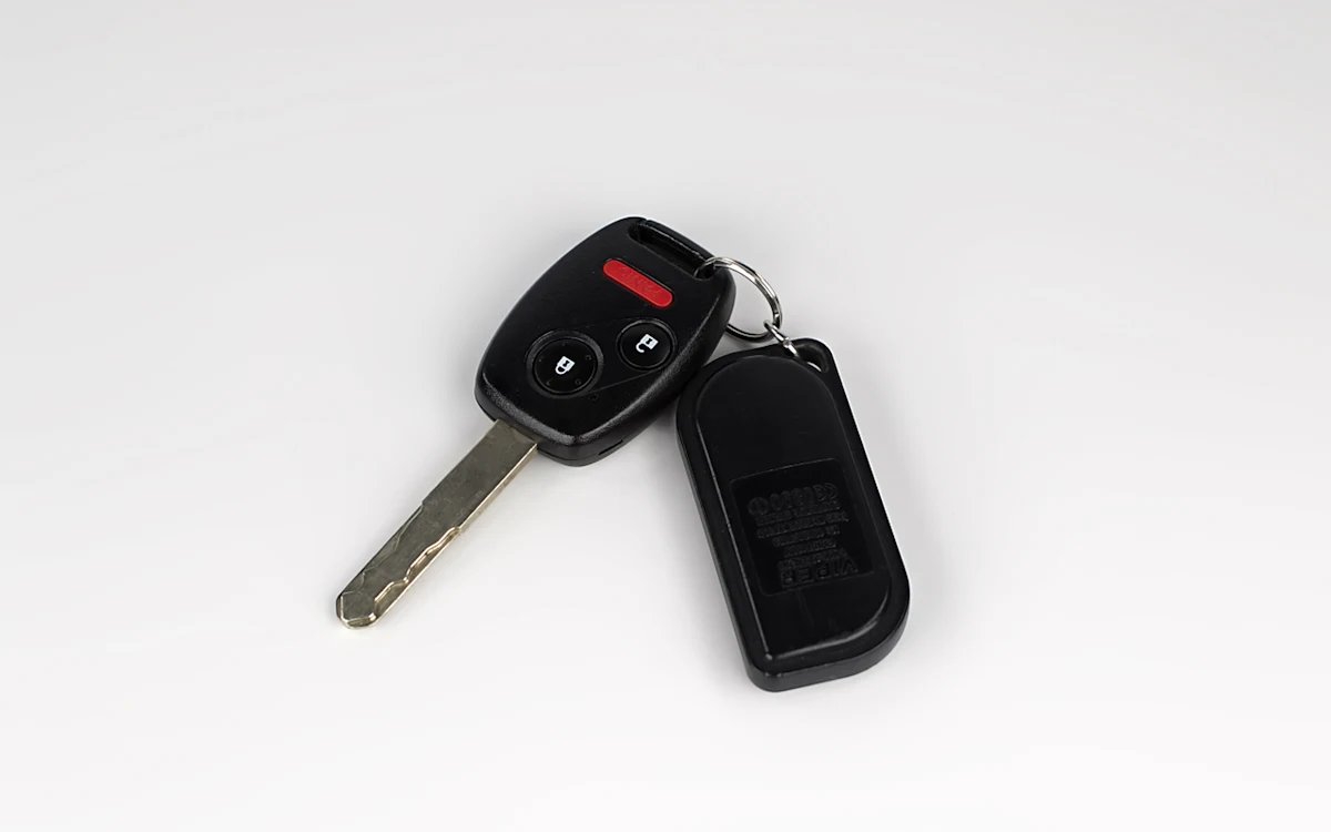 Llave de auto negra con control remoto sobre un fondo liso